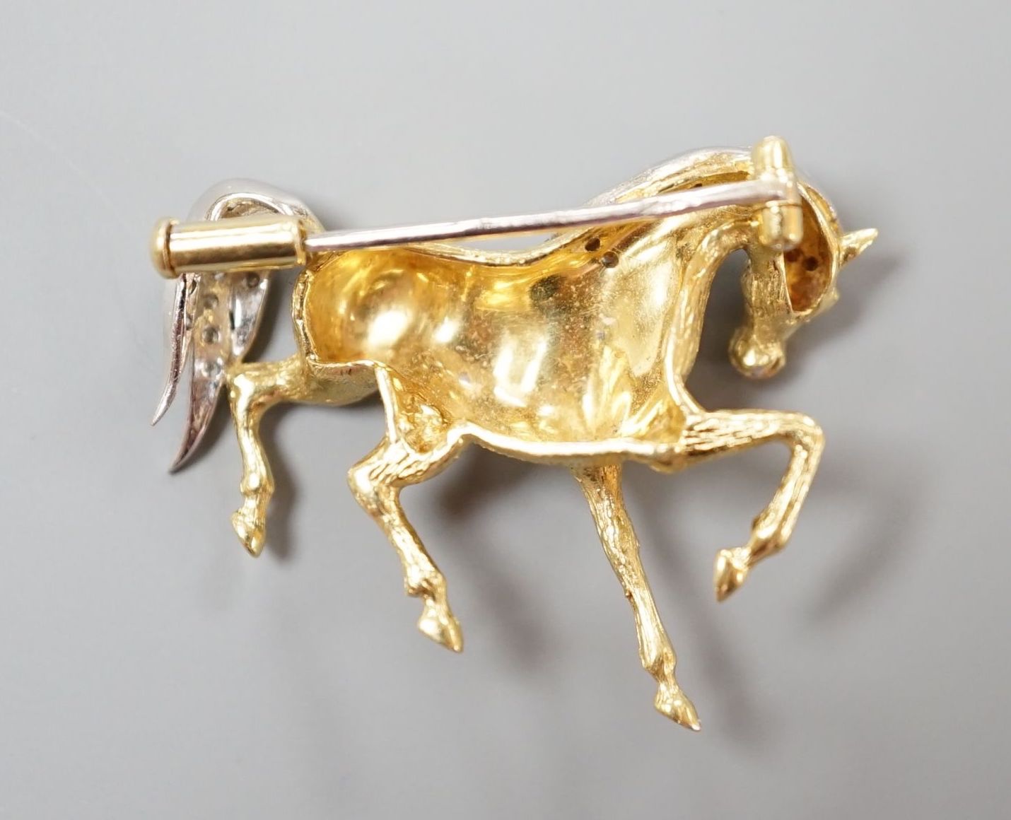 A modern 18ct gold and diamond chip set horse brooch, 29mm, gross weight 7.4 grams.